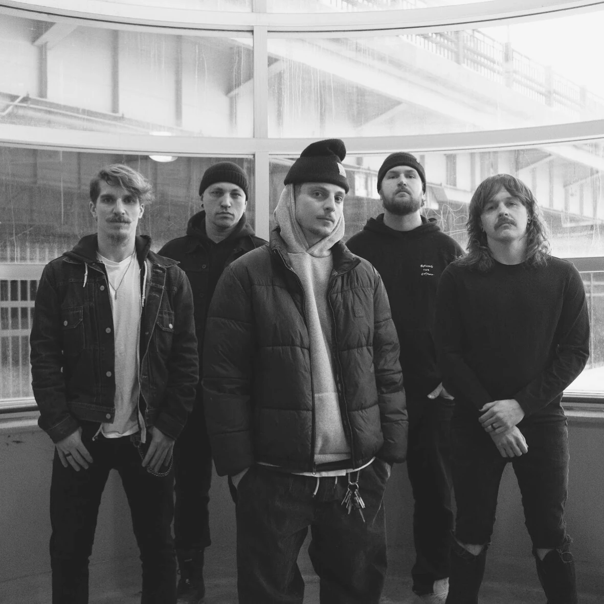 F!TH band portrait by a curved window